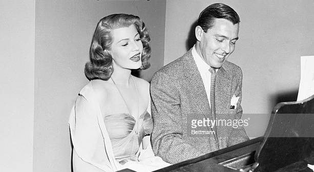 A atriz Rita Hayworth ao piano com Fred Karger, da Columbia Pictures, no set do filme de 1952, Caso em Trindade. Getty Images