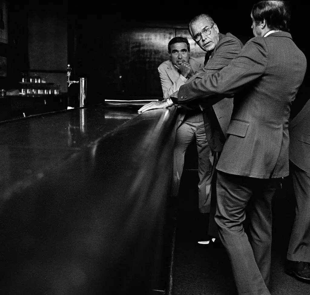 Sr. Rohatyn, na retaguarda, com William M. Ellinghaus, no centro, então presidente da Corporação de Assistência Municipal, e um homem não identificado no Americana Hotel em Manhattan em 1975, durante negociações sobre a crise fiscal da cidade. Os homens esperaram em um bar fechado até que uma sala de reuniões fosse encontrada.Crédito...Neal Boenzi/The New York Times