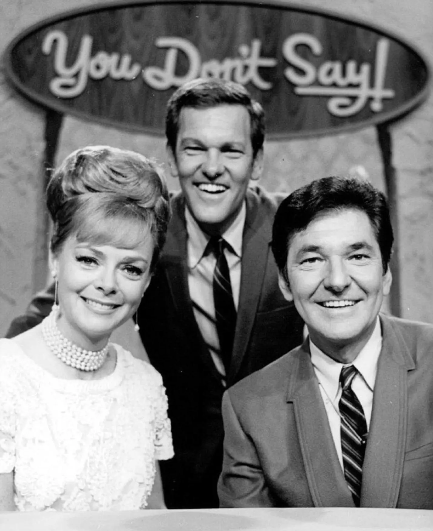 O Sr. Kennedy, no centro, enquanto apresentava o game show de celebridades “You Don't Say!” em 1968, acompanhado pela atriz June Lockhart e Jack Narz, irmão do Sr. Kennedy e também apresentador do game show. (Crédito da fotografia: Arquivo PL/Alamy Stock Photo)