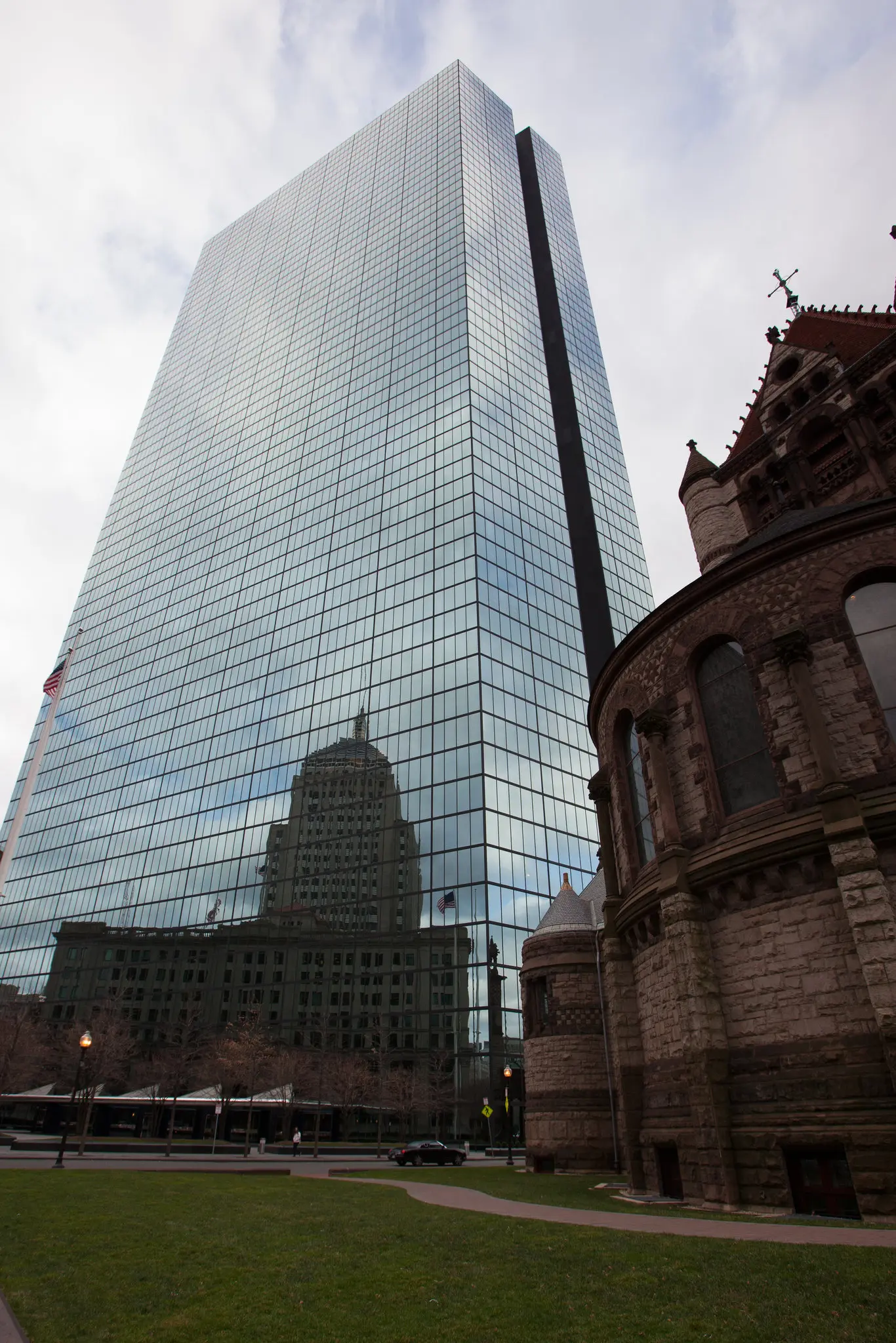 A Torre John Hancock em 2011. A ideia do edifício inicialmente atraiu críticas por ofuscar a Copley Square e a Trinity Church, à direita. (Crédito...Evan McGlinn para o The New York Times)