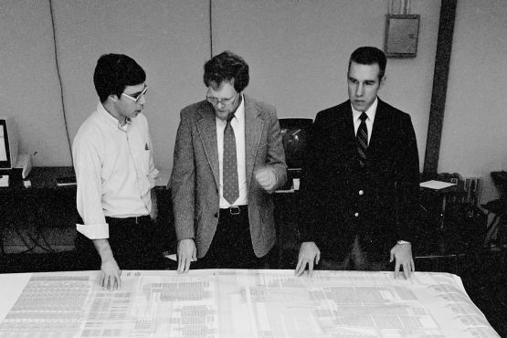 Em 1984, os professores de engenharia elétrica James D. Meindl (à direita) e John Hennessy (ao centro) fazem um brainstorming com o engenheiro de pesquisa John Shott sobre o projeto MIPS, que simplificou computadores com arquitetura RISC. (Crédito da imagem: Chuck Painter / Stanford News Service)