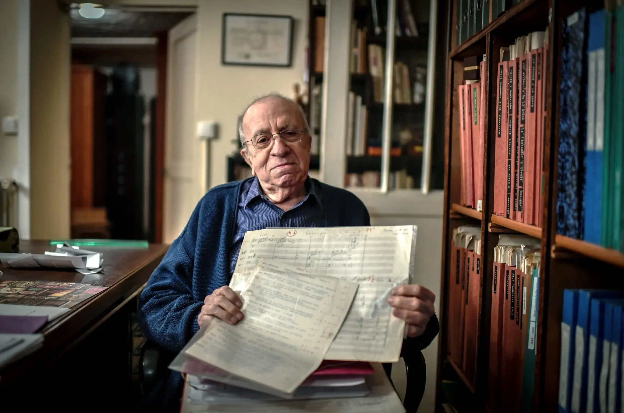 O Sr. Solal, posando com algumas de suas partituras musicais, em sua casa em Chatou, França, em 2018. Ele deu seu último concerto no ano seguinte em Paris, aos 91 anos.Crédito...Stéphane De Sakutin/Agência France-Presse — Getty Images