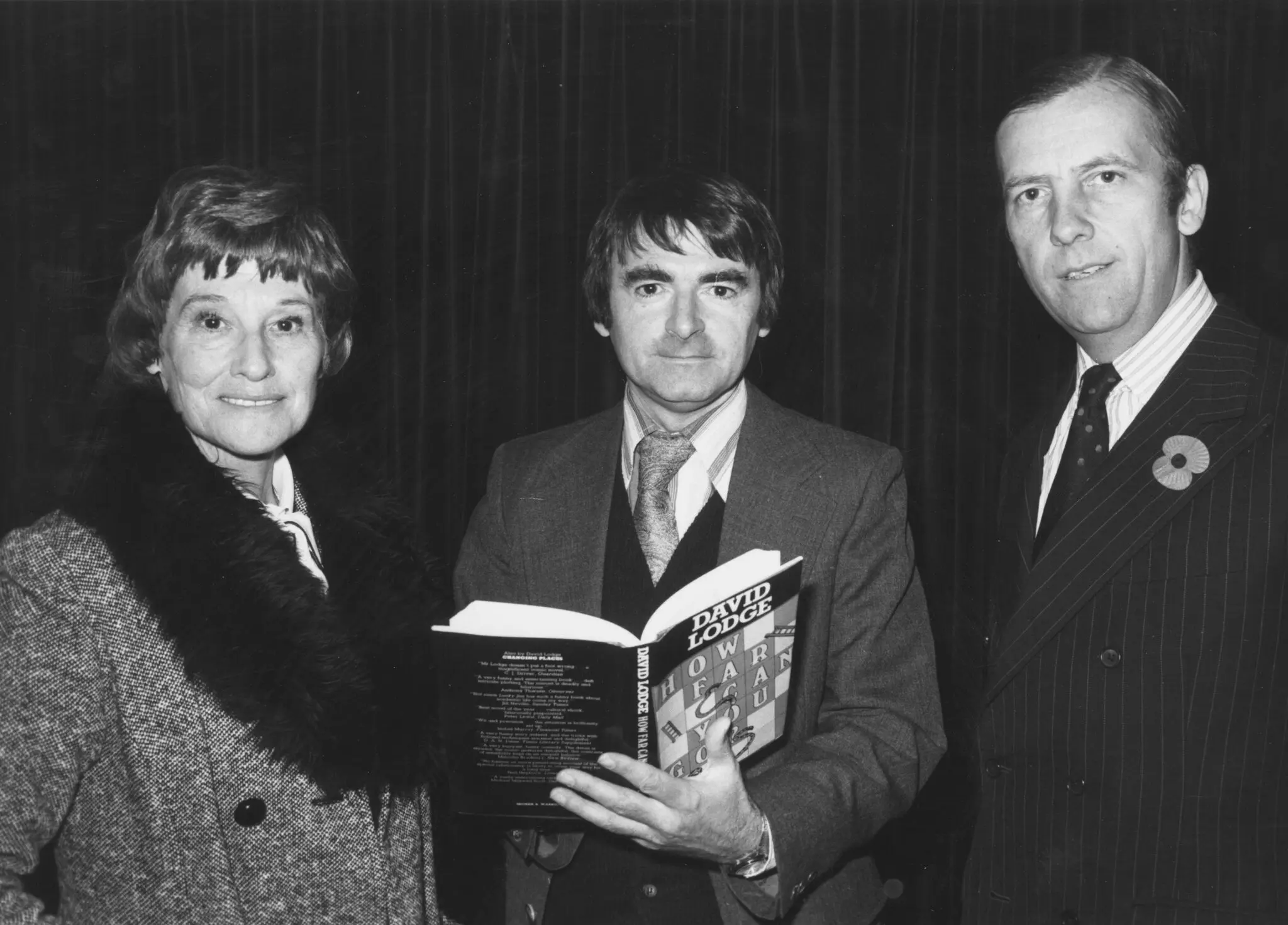 O Sr. David Lodge, no centro, foi homenageado em 1980 com o Prêmio Whitbread de Livro do Ano por seu romance “How Far Can You Go?” Ele estava ladeado por Sam Whitbread, da empresa patrocinadora, e pela escritora inglesa Penelope Mortimer.Crédito...David Levenson/Keystone, via Getty Images