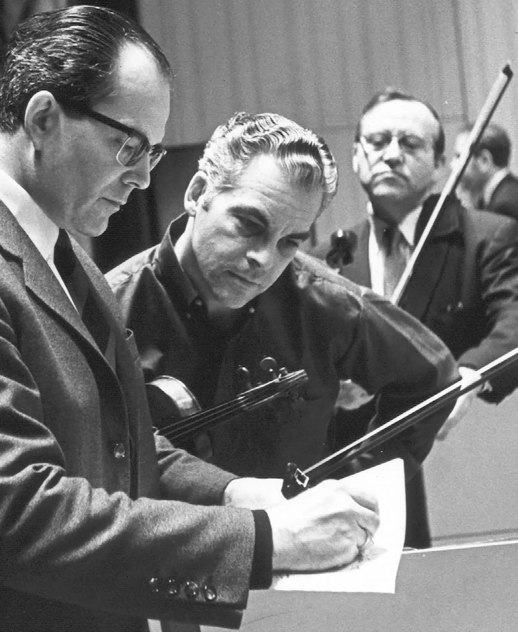 O Sr. Norman Carol, no centro, conversou com o maestro da Orquestra da Filadélfia, Wolfgang Sawallisch, à esquerda, em 1966.Crédito...Coleção Adrian Siegal/via Philadelphia Orchestra